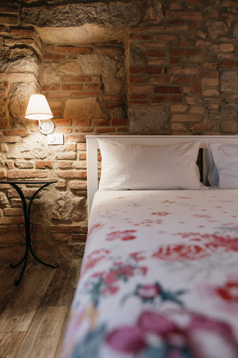 profesionální fotografie apartmánu v Itálii - interiér ložnice postel, noční stolek lampa