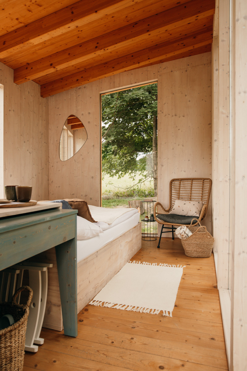 Interiérová fotografie glampingu OOTOOLNO Země – minimalistický design, dřevěný interiér a klidná atmosféra místa.